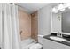 Cozy bathroom featuring a shower and bath with tiled walls and a black granite countertop sink at 402 E Orlando Ave # 18C, Ocoee, FL 34761