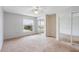 Well-lit bedroom with lakeside views, soft carpet, a ceiling fan, and mirrored closet doors at 402 E Orlando Ave # 18C, Ocoee, FL 34761