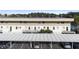Apartment building featuring balconies, covered parking, and modern architecture with a view of the lake at 402 E Orlando Ave # 18C, Ocoee, FL 34761