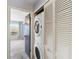 In-unit laundry featuring stackable washer/dryer nestled within custom white louvered door cabinetry at 402 E Orlando Ave # 18C, Ocoee, FL 34761