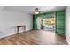 Bright living room with hardwood flooring, a ceiling fan, and a sliding glass door to the balcony at 402 E Orlando Ave # 18C, Ocoee, FL 34761