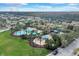 Beautiful aerial view showcasing a community with a swimming pool, clubhouse, playground, and green spaces among homes at 4036 Bougainvillea Pl, Kissimmee, FL 34746