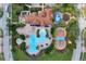 Aerial view of a community featuring a swimming pool, clubhouse, playground, and meticulously landscaped grounds at 4036 Bougainvillea Pl, Kissimmee, FL 34746
