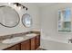 Bathroom featuring a granite counter with double sinks and a separate tub at 4036 Bougainvillea Pl, Kissimmee, FL 34746