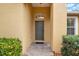 Inviting entryway showcasing a gray front door with a transom window and neat landscaping at 4036 Bougainvillea Pl, Kissimmee, FL 34746
