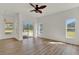 Light-filled living room featuring wood floors, a ceiling fan, and sliding glass doors to the outdoor area at 4036 Bougainvillea Pl, Kissimmee, FL 34746