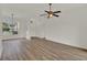 Spacious living room with wood floors, a ceiling fan, and a view to the backyard at 4036 Bougainvillea Pl, Kissimmee, FL 34746