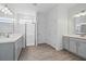 Elegant bathroom with double sinks, gray vanities, and a glass-enclosed shower at 4110 Gooseberry Trl, Kissimmee, FL 34746