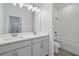Bright bathroom with double sinks, a large mirror, and a separate tub/shower combination at 4110 Gooseberry Trl, Kissimmee, FL 34746
