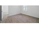An empty room with new flooring is illuminated by natural light from a window at 4110 Gooseberry Trl, Kissimmee, FL 34746