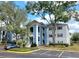 Well-maintained condo building with blue and grey exterior paint, reserved parking, and mature trees at 4304 Clubside Dr # 4304, Longwood, FL 32779