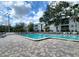 Large community pool with brick paver deck and lounge chairs under shady trees at 4304 Clubside Dr # 4304, Longwood, FL 32779