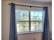 A bright window with blue drapes provides tranquil view of lush greenery and blue sky at 4304 Clubside Dr # 4304, Longwood, FL 32779