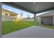 Covered back patio with concrete flooring, overlooking a spacious fenced yard at 4472 Lions Gate Ave, Clermont, FL 34711