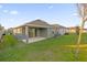 Spacious backyard with lush lawn, covered patio, and modern home exterior at 4472 Lions Gate Ave, Clermont, FL 34711