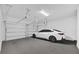Clean, well-lit garage featuring epoxy flooring and a modern car at 4472 Lions Gate Ave, Clermont, FL 34711