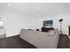 Spacious living room with a large sofa, entertainment center, and sleek flooring at 4472 Lions Gate Ave, Clermont, FL 34711