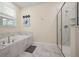 This bathroom features a soaking tub, a glass-enclosed shower, and marble flooring at 4532 Target Blvd, Kissimmee, FL 34746