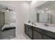This bathroom features double sinks, modern vanity, and an open doorway to the bedroom at 4532 Target Blvd, Kissimmee, FL 34746