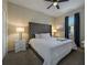 This bedroom includes a tufted headboard, bedside tables, and a bright window at 4532 Target Blvd, Kissimmee, FL 34746