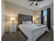 Comfortable bedroom featuring a king bed with a tufted headboard, side tables and dark curtains at 4532 Target Blvd, Kissimmee, FL 34746