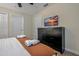 Well-lit bedroom featuring a TV, black dresser, and a relaxing ambiance for a comfortable stay at 4532 Target Blvd, Kissimmee, FL 34746