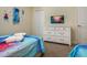 Bright bedroom featuring a TV, white dresser with sleek hardware, and comfortable sleeping accommodations at 4532 Target Blvd, Kissimmee, FL 34746