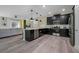Open kitchen features stainless steel appliances, gray wood-look flooring, and black cabinets at 4532 Target Blvd, Kissimmee, FL 34746