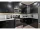 Close up of kitchen with stainless steel appliances, white tile backsplash, and black cabinets at 4532 Target Blvd, Kissimmee, FL 34746