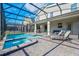 Large screened-in pool features an attached spa, lounge chairs, and patio furniture at 4532 Target Blvd, Kissimmee, FL 34746