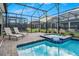 Screened-in pool and spa features lounge chairs, table, and chairs at 4532 Target Blvd, Kissimmee, FL 34746