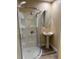 Bathroom featuring a corner shower and a stylish pedestal sink with a round mirror at 4770 Cains Wren Trl, Sanford, FL 32771