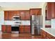 Spacious kitchen featuring stainless steel appliances, dark cabinets, white countertops and hardwood flooring at 4770 Cains Wren Trl, Sanford, FL 32771