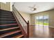Beautiful wood staircase with black wrought iron spindles, adjacent to sliding glass doors and pond view at 4770 Cains Wren Trl, Sanford, FL 32771