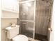 Modern bathroom featuring a glass-enclosed shower, white toilet, and storage cabinet at 5016 Fawn Ridge Rd, Orlando, FL 32819
