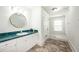 Well-lit bathroom featuring white cabinets and a unique green countertop paired with tile flooring and a glass enclosed shower at 520 E Anderson St, Orlando, FL 32801