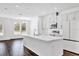 A kitchen with a large island, white cabinets, modern appliances, and hardwood flooring at 6403 Cyrils Dr, St Cloud, FL 34771