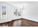 Spacious living room featuring hardwood floors, a modern chandelier, and large windows for ample natural light at 6403 Cyrils Dr, St Cloud, FL 34771