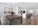 Bright living room featuring wood floors, modern decor, a chandelier, and an open kitchen at 6403 Cyrils Dr, St Cloud, FL 34771
