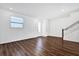 Bright living room with wood floors, a window, and a staircase with white railings at 6403 Cyrils Dr, St Cloud, FL 34771