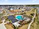 Community pool area with lounge chairs and umbrellas surrounded by walkways and green space in residential neighborhood at 6403 Cyrils Dr, St Cloud, FL 34771