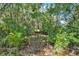 Secluded backyard nook features a rustic outdoor seating area surrounded by lush tropical foliage at 873 Gulf Land Dr, Apopka, FL 32712