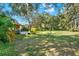 Large backyard with a well-maintained lawn, mature trees, and landscaping, offering a private outdoor space at 873 Gulf Land Dr, Apopka, FL 32712