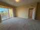 Bedroom with neutral carpet and access to a private balcony overlooking the community at 8775 Sartori St # 303, Orlando, FL 32829