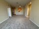 Open-concept living room featuring neutral carpeting, and arched entryways to other rooms at 8775 Sartori St # 303, Orlando, FL 32829