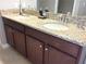 Bathroom featuring a double sink vanity with a granite countertop and dark wood cabinetry at 8950 Azalea Sands Ln # 8950, Champions Gate, FL 33896