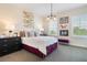 Stylish bedroom featuring decorative wall art, two windows, and a cozy seating area at 896 Tilden Oaks Trl, Winter Garden, FL 34787