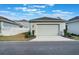 View of the detached garage with a concrete driveway in front of the house and a green lawn at 896 Tilden Oaks Trl, Winter Garden, FL 34787