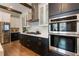 Modern kitchen with stainless steel appliances, stylish dark cabinets, and a sleek range hood at 896 Tilden Oaks Trl, Winter Garden, FL 34787