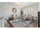 Elegant living room with modern furniture, accent wall, and a decorative round mirror at 896 Tilden Oaks Trl, Winter Garden, FL 34787